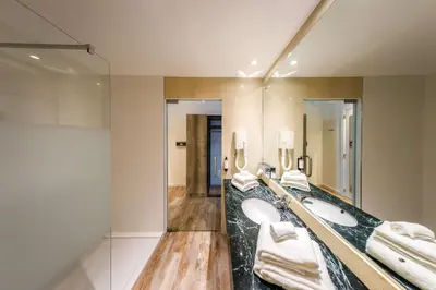 a bathroom with two sinks and a large mirror at B-INN Lier in Lier