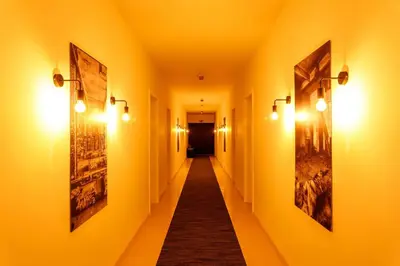 a long hallway with lights and paintings on the walls at B-INN Lier in Lier