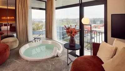a large bathroom with a tub with a large window at Van der Valk Hotel Beveren in Beveren