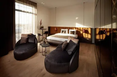 a bedroom with a bed and two couches at Van der Valk Hotel Beveren in Beveren