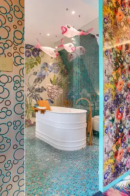a bathroom with a tub and a wall of flowers at Hotel De Witte Lelie -Small Luxury Hotels of the World in Antwerp