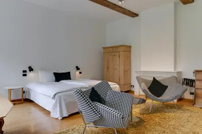 a bedroom with a bed and chairs in a room at Hotel De Witte Lelie -Small Luxury Hotels of the World in Antwerp