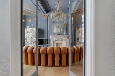 a room with a chandelier and a row of brown chairs at Hotel De Witte Lelie -Small Luxury Hotels of the World in Antwerp