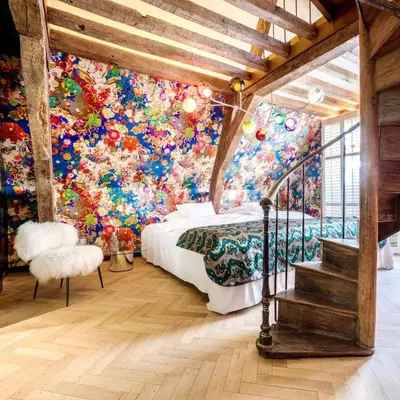 a bedroom with a colorful wall of flowers at Hotel De Witte Lelie -Small Luxury Hotels of the World in Antwerp
