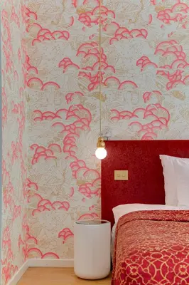 a bedroom with a bed and a red wall at Hotel De Witte Lelie -Small Luxury Hotels of the World in Antwerp