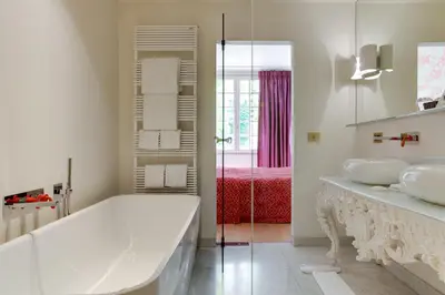 a white bathroom with two sinks and a tub at Hotel De Witte Lelie -Small Luxury Hotels of the World in Antwerp