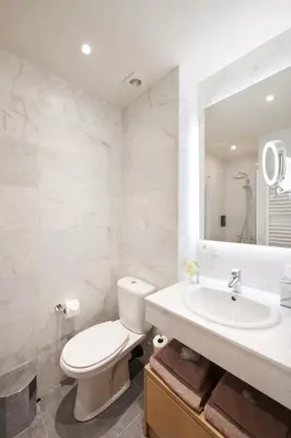 a bathroom with a toilet and a sink and a mirror at Hotel Royal Astrid in Aalst