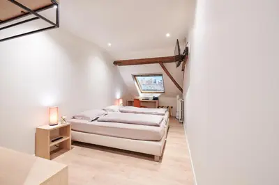 a bedroom with a white bed and a television at Hotel Royal Astrid in Aalst
