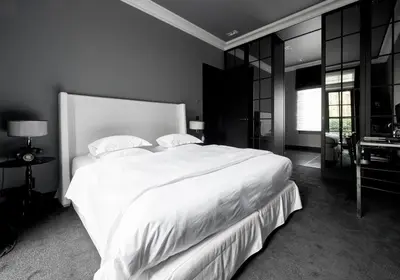 a bedroom with a large white bed and a desk at Hotel Odette en Ville in Brussels
