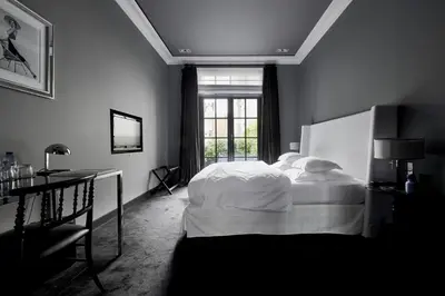 a black and white bedroom with a bed and a window at Hotel Odette en Ville in Brussels
