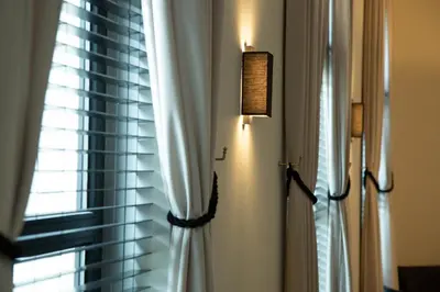a window with a white curtain and a lamp at Hotel Kasteel Solhof in Aartselaar