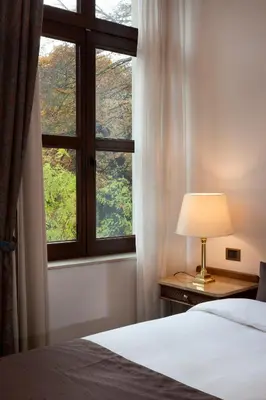 a bedroom with a bed and a window at Hotel Kasteel Solhof in Aartselaar