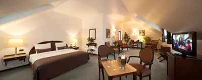 a hotel room with a bed and tables and chairs at Hotel Kasteel Solhof in Aartselaar