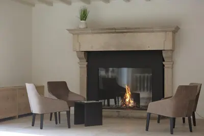 a living room with chairs and a fireplace at Corsendonk Hooge Heyde in Lichtaart