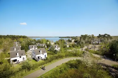 an aerial view of a village with houses and a lake at Sunparks Kempense Meren in Mol