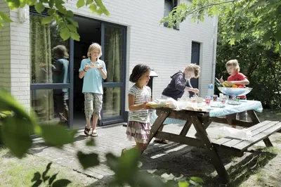 a group of children standing around a picnic table at Sunparks Kempense Meren in Mol