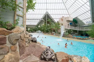 a group of people in a swimming pool in a building at Sunparks Kempense Meren in Mol