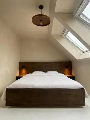 a bedroom with a large bed and two windows at Edville Studio in Ghent