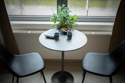 a table with two chairs and a potted plant on it at Edville Studio in Ghent
