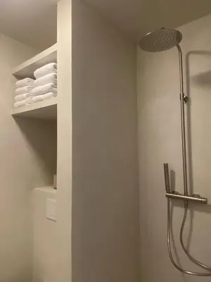 a bathroom with a shower and some white towels at Edville Studio in Ghent