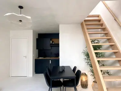 a room with a table and chairs and a staircase at Edville Studio in Ghent
