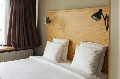 a bedroom with a bed with white sheets and pillows at JAM Brussels in Brussels