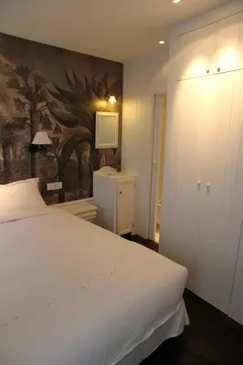 a bedroom with a white bed and a painting on the wall at L'Epicentre in Brussels