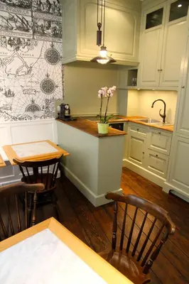 a kitchen with white cabinets and a table and chairs at L'Epicentre in Brussels