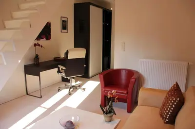 a living room with a chair and a desk at Luxury Suites Arendshof in Antwerp