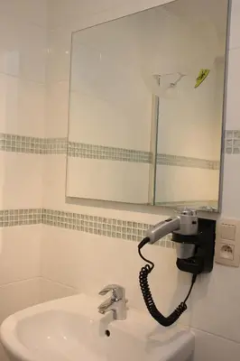 a bathroom with a blow dryer attached to a sink at Luxury Suites Arendshof in Antwerp
