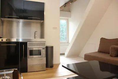 a kitchen with a stainless steel stove and a couch at Luxury Suites Arendshof in Antwerp