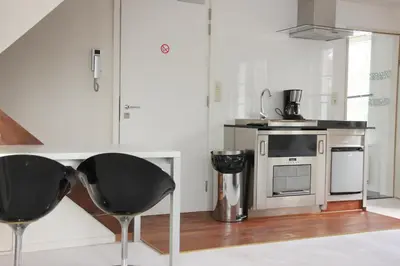 a kitchen with two black chairs and a microwave at Luxury Suites Arendshof in Antwerp