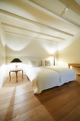 a bedroom with a large white bed and a table at B&B Maryline in Antwerp