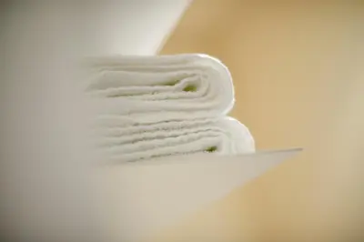 a stack of white towels sitting on a shelf at B&B Maryline in Antwerp