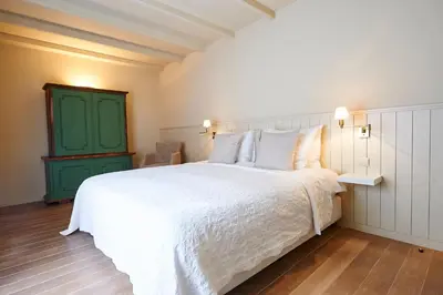 a bedroom with a white bed and a green door at B&B Maryline in Antwerp