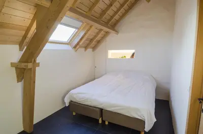 a bed in a small room with a window at Eyndevelde in Herzele