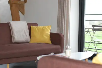 a living room with a couch and a yellow pillow at Eyndevelde in Herzele