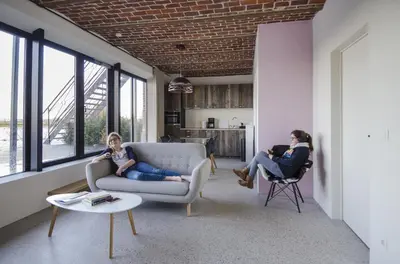 two women sitting in a living room with a couch at Eyndevelde in Herzele