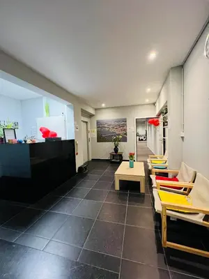 a lobby with chairs and tables in a building at Munal Hotel Temse in Temse