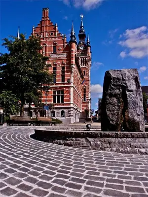a large brick building with a rock in front of it at Munal Hotel Temse in Temse