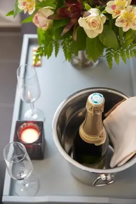 a bottle of wine in a bucket on a table with flowers at Munal Hotel Temse in Temse
