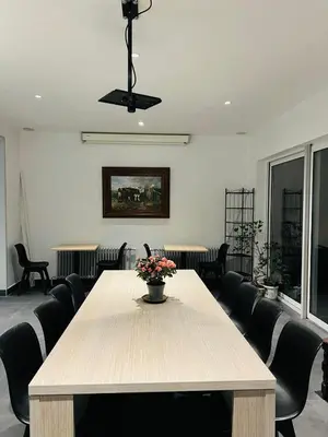 a room with a table with a vase of flowers on it at Munal Hotel Temse in Temse