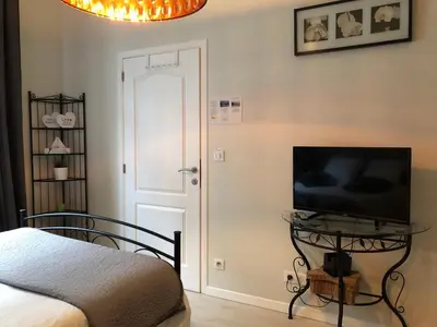 a bedroom with a bed and a television on a table at Petit Appartement Jourdan EU in Brussels