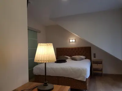 a bedroom with a bed with a lamp and a staircase at Hôtel Méribel in Brussels