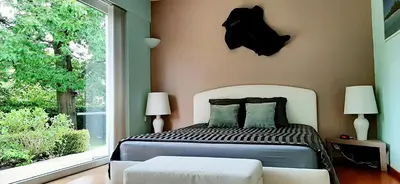 a bedroom with a bed and a large window at B&B prince d’Orange Waterloo in Waterloo