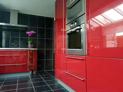a red kitchen with a stove and a red wall at B&B prince d’Orange Waterloo in Waterloo