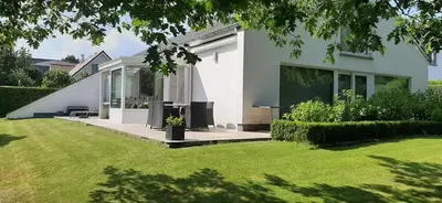 a white house with a patio and a yard at B&B prince d’Orange Waterloo in Waterloo