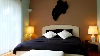 a bedroom with a bed with pillows and two lamps at B&B prince d’Orange Waterloo in Waterloo