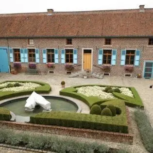 a house with a garden with a pond in front of it at Onsemhoeve in Dilbeek