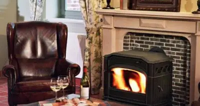 a living room with a fireplace and a chair and a table at Onsemhoeve in Dilbeek